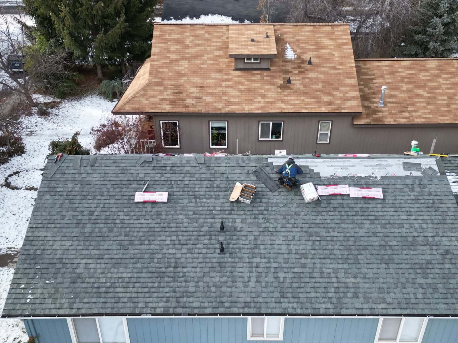 Greenlee crew installing gray architectural shingles on a single-story Bend home in winter